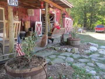 Woman on wooden swing sitting in front of ranch